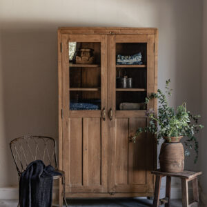 Vintage teak wardrobe with solid panel doors and brass handle, styled with vintage trunk and eucalyptus — Soulosofie Mallorca