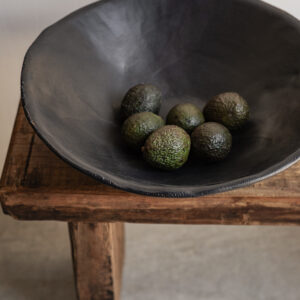 Large handmade black stoneware bowl by Badass Ceramics with raw organic rim, styled on reclaimed wood bench — Soulosofie Mallorca