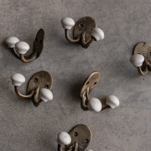 Brass wall hook with white ceramic knob, rustic handmade finish — Soulosofie Mallorca