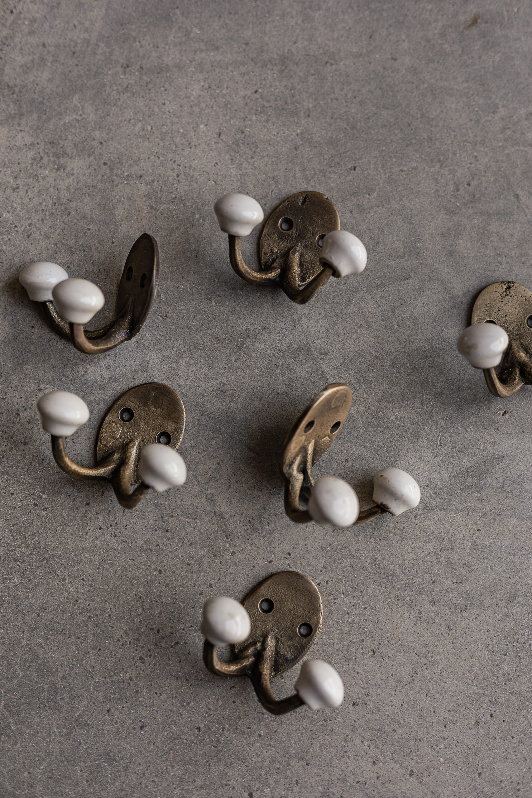 Brass wall hook with white ceramic knob, rustic handmade finish — Soulosofie Mallorca