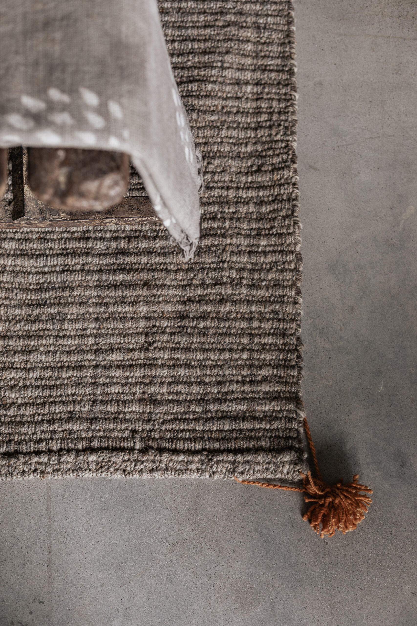 Handwoven wool carpet in natural beige with tassel detail, textured weave close-up — Soulosofie Mallorca
