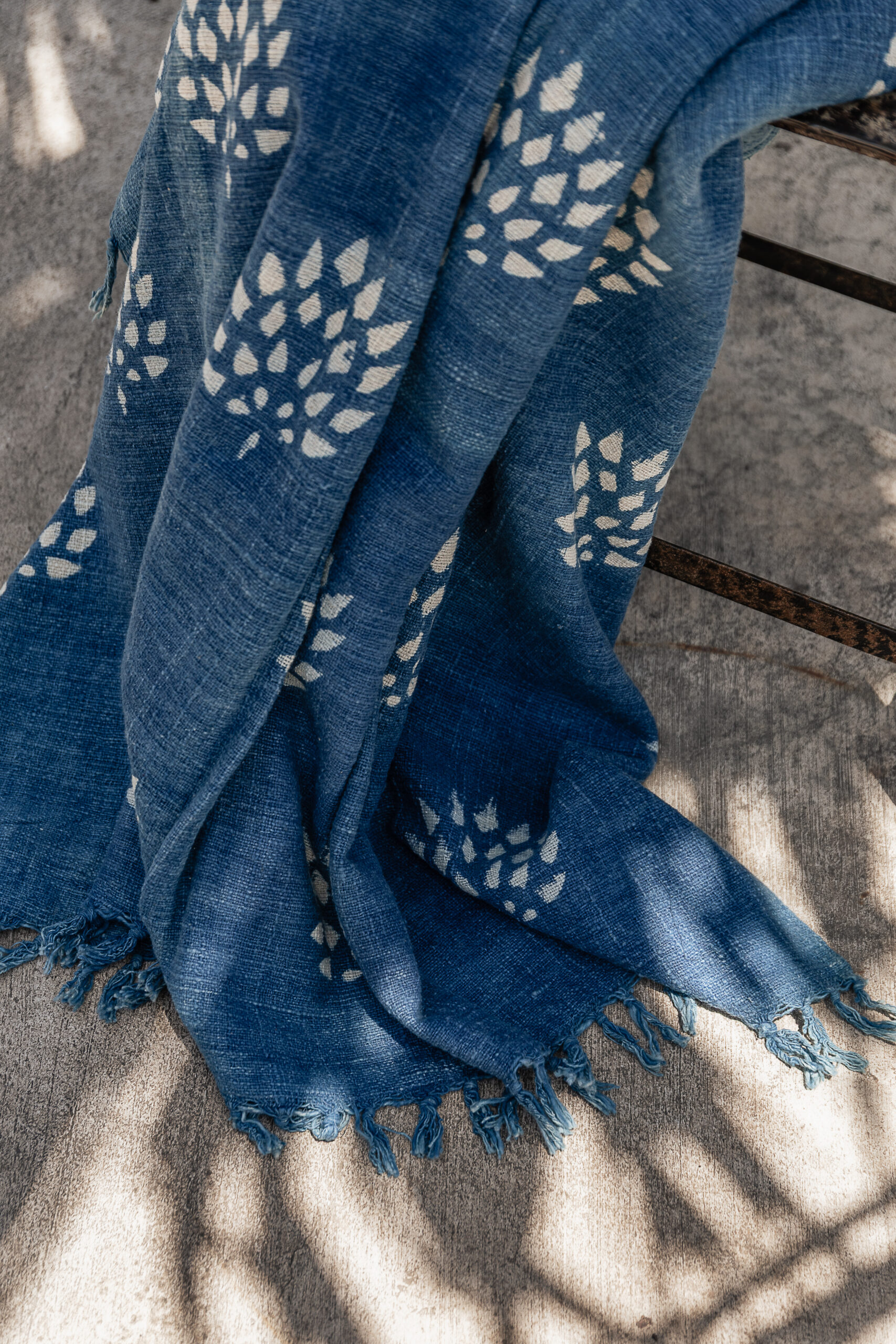 Close-up of indigo blue handwoven cotton throw with white block print floral pattern — Soulosofie Mallorca