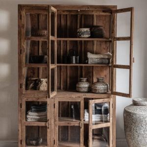 Large reclaimed teak cabinet with glass doors and open shelves, styled with vintage ceramics and textiles — Soulosofie Mallorca