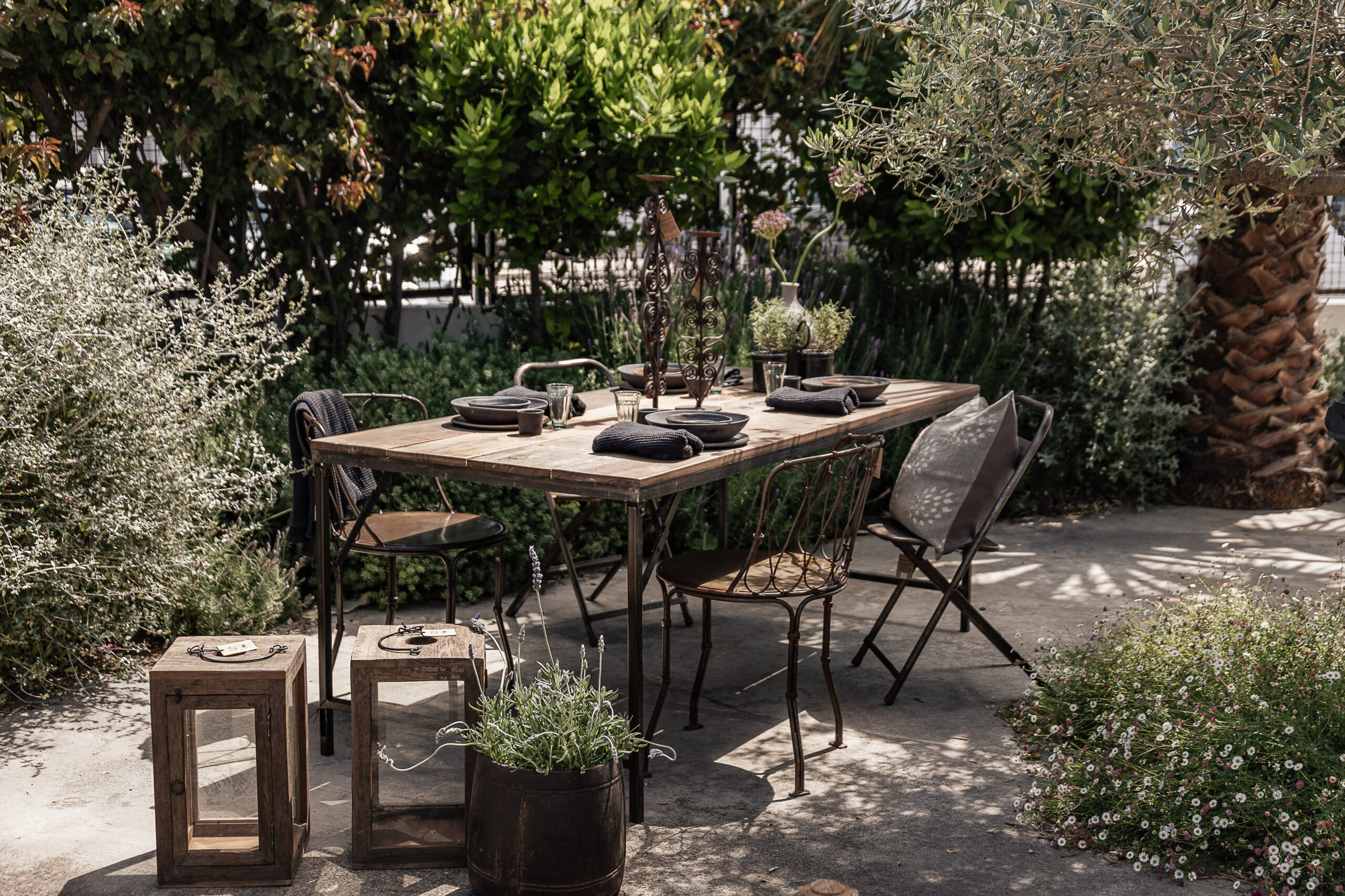 Reclaimed wood outdoor dining table surrounded by lavender garden, styled with handmade ceramics and stoneware vase — Soulosofie Mallorca