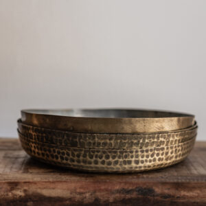 Vintage round hammered brass tray with warm patina finish, stacked set on reclaimed wood — Soulosofie Mallorca