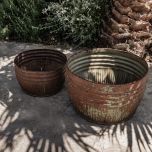 Pair of vintage iron planters with rusty patina and peeling paint, styled outdoors in a Mediterranean garden — Soulosofie Mallorca