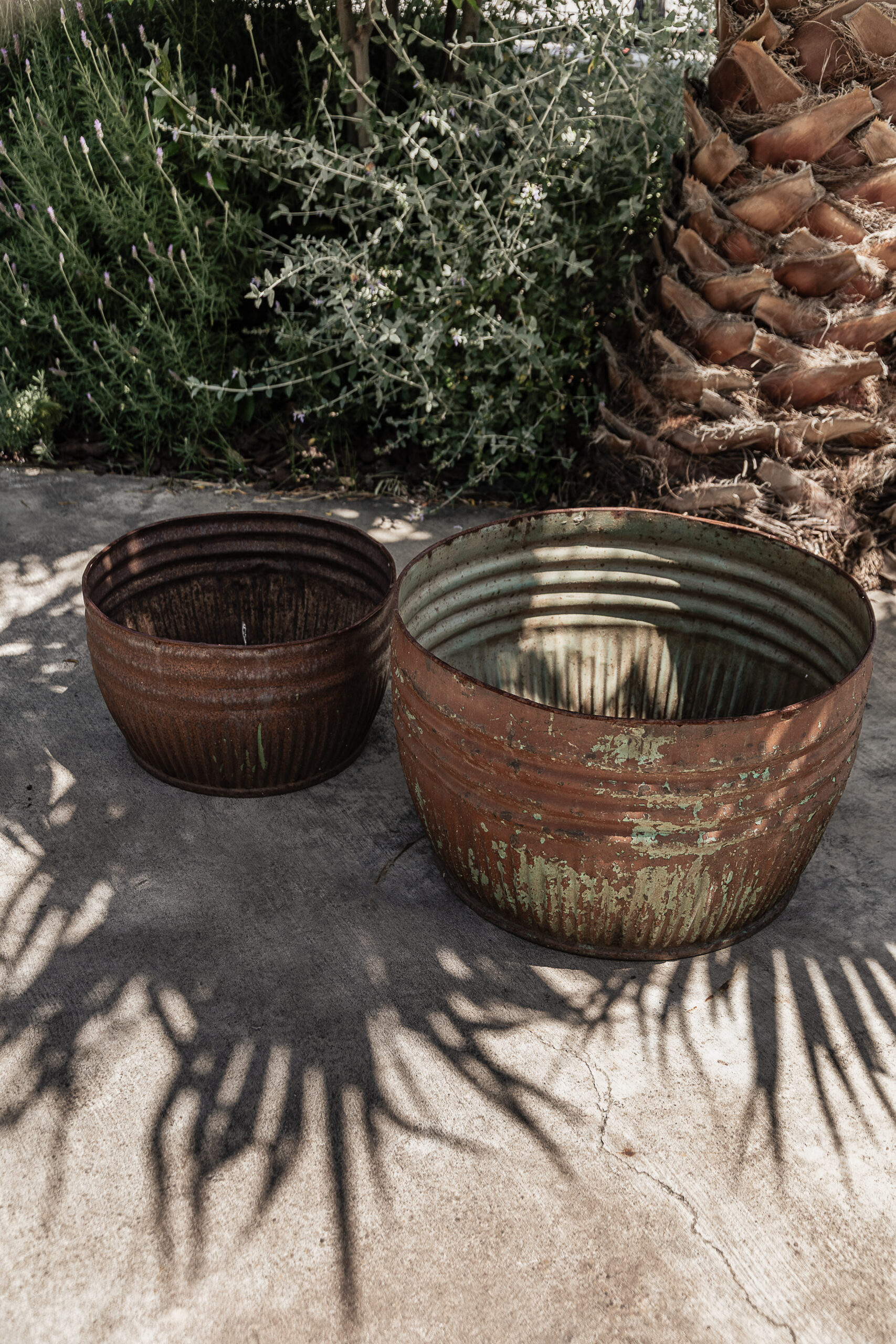 Pair of vintage iron planters with rusty patina and peeling paint, styled outdoors in a Mediterranean garden — Soulosofie Mallorca