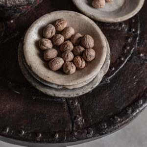 Vintage round iron coffee table with rustic riveted detail, styled with stone plates — Soulosofie Mallorca