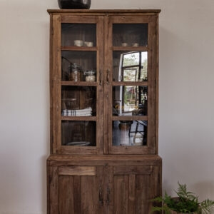 Vintage teak display cabinet with glass panel doors and solid lower cupboard, styled with ceramics and green glassware — Soulosofie Mallorca