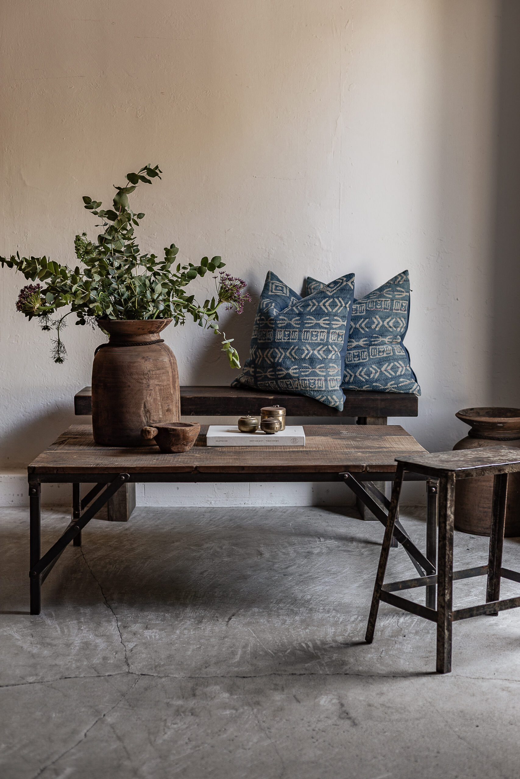 Reclaimed wood sofa table with iron legs, styled with vintage clay pot and indigo cushions — Soulosofie Mallorca