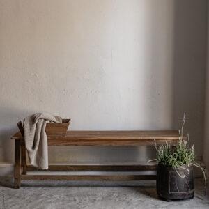 Long vintage teak bench with natural warm grain finish, styled with linen throw and lavender — Soulosofie Mallorca