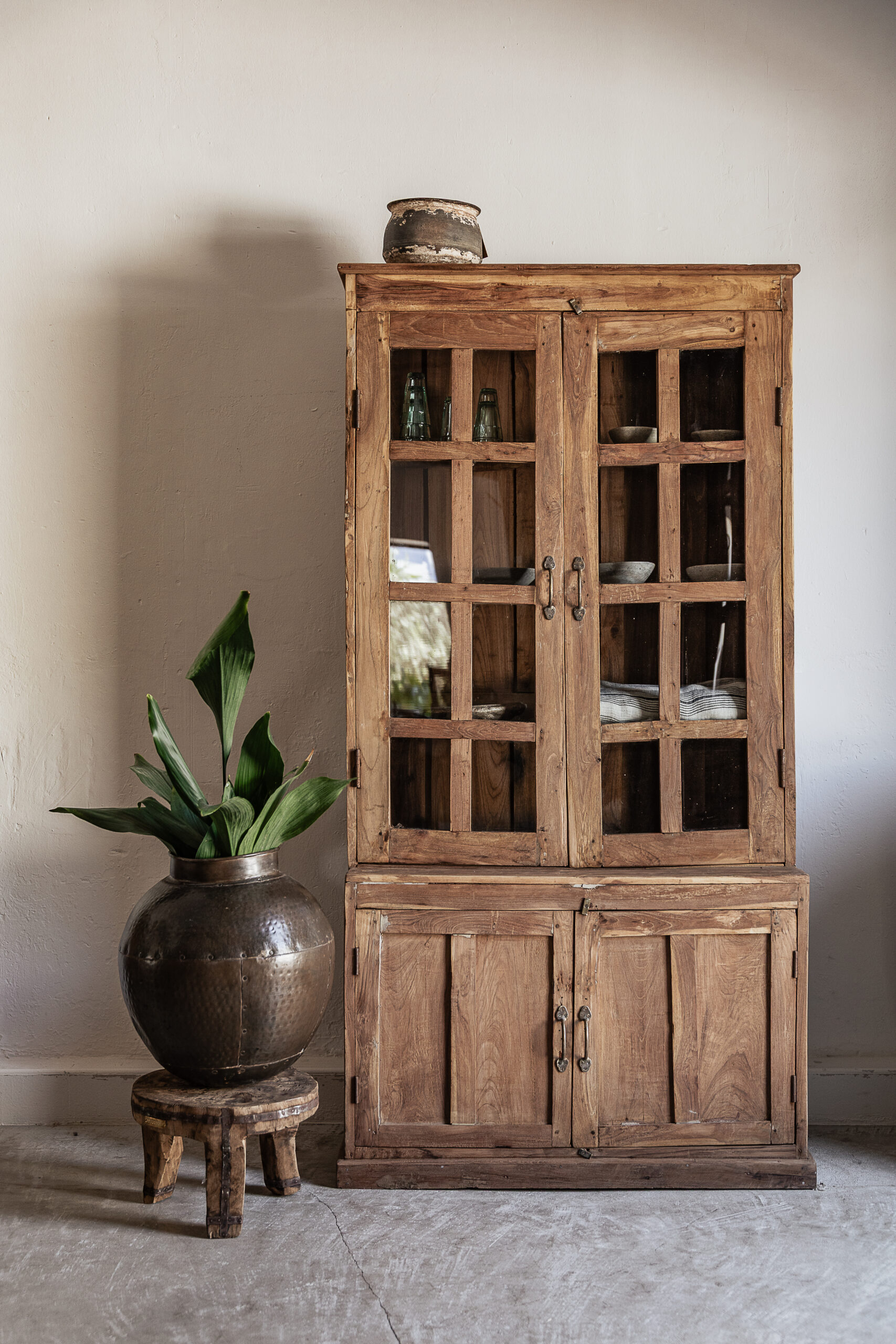 Tall vintage teak kitchen cabinet with glass display doors and solid lower storage, styled with dried lavender and stoneware — Soulosofie Mallorca